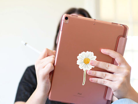 image shows an ipad with a White Daisy Flower sticker on the back.