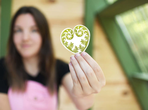 image shows a woman holding a Fern leaf vinyl sticker for your water bottle, laptop, car sticker, journal, window, or other smooth surface.