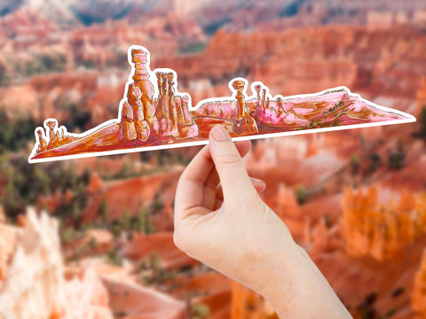 10" long extra large vinyl sticker that portrays a rocky scene from Bryce Canyon Utah in beautiful orange, pink, and red tones. Waterproof, scratch and weather-resistant, you can put these stickers on all of your outdoor gear like your favorite tumbler or water bottle, no matter what the size!